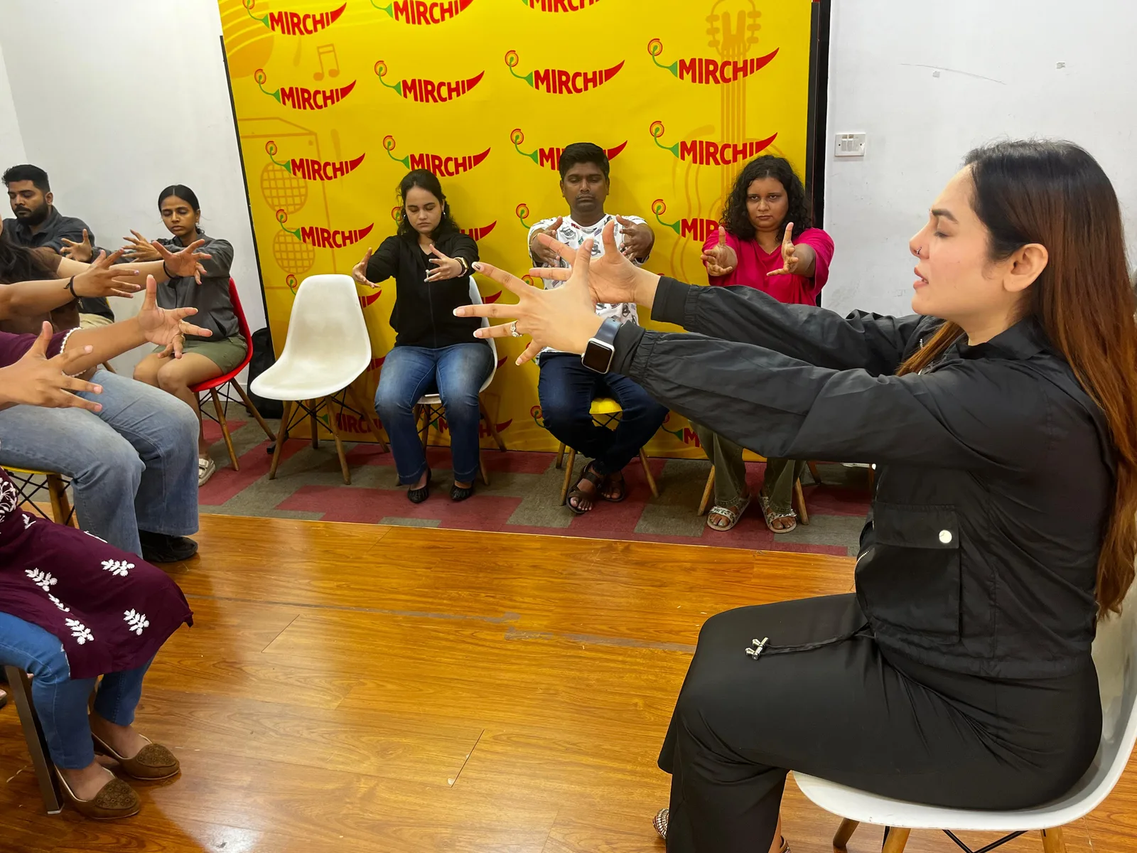 Vibha Jain seated opposite a group of participants during a guided relaxation and awareness workshop.